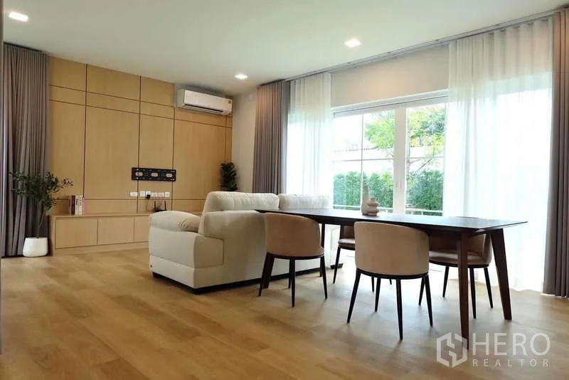 Detached House for rent in Bang Phli, Samut Prakan - Open‑plan living and dining room with wide glazing and sheer curtains.