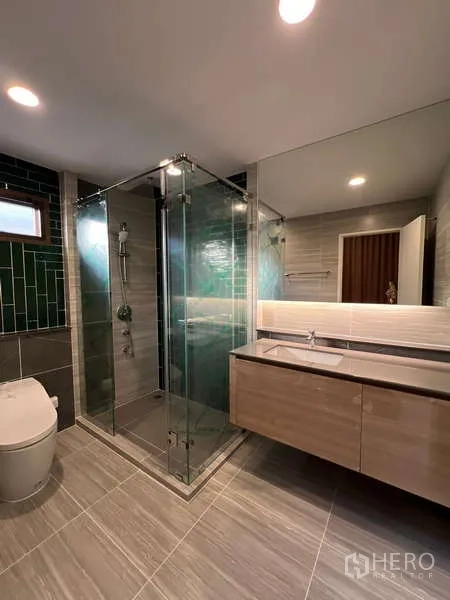Detached House for rent in Bang Kapi, Bangkok - Modern bathroom with glass shower enclosure, floating vanity and green tile accent wall.