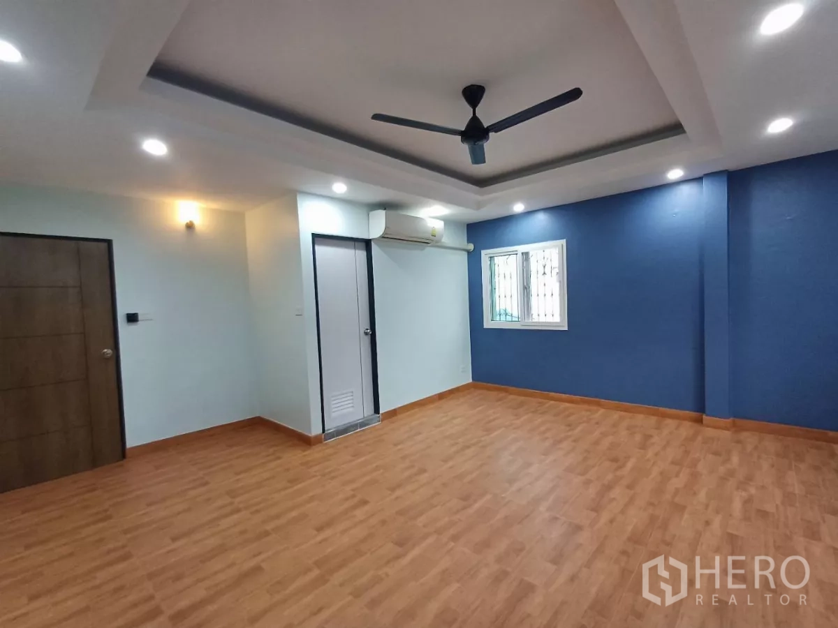 带办公室的家 出租在Phra Khanong, Bangkok - 主卧，蓝色强调墙，吊扇与空调。