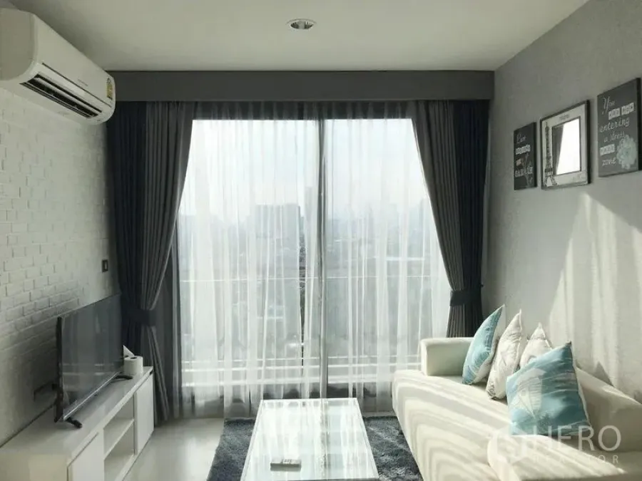 Condominium for rent in Khlong Toei, Bangkok - Living room with floor-to-ceiling glass bringing city views and natural light.