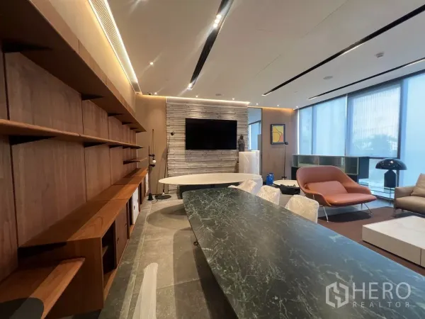 Retail Space for rent - Built-in wooden shelving wall, stone feature wall with mounted TV and a green marble table in the showroom area.