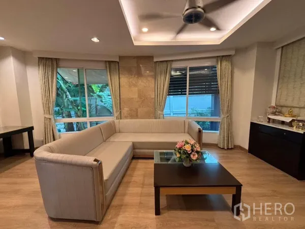 Detached House for rent in Bang Kapi, Bangkok - Cozy lounge with ceiling fan, corner windows and coffee table.