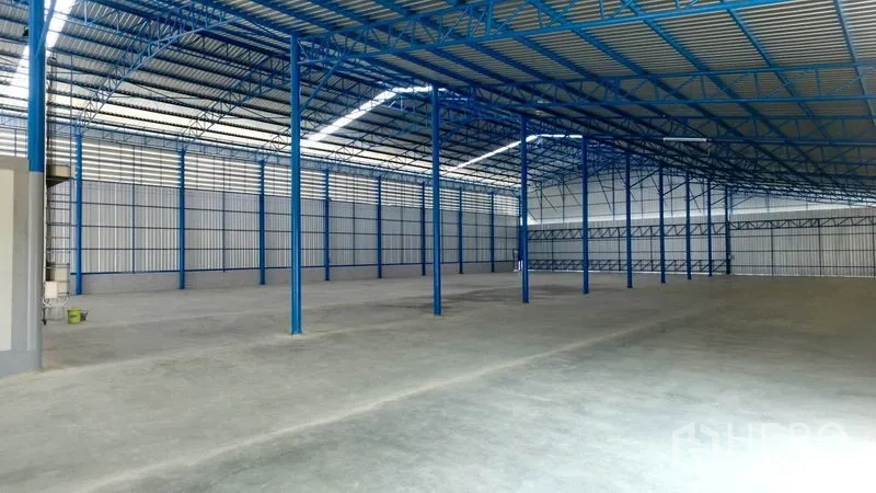 Factory for rent in Mueang Samut Sakhon, Samut Sakhon - Spacious warehouse interior with high ceiling, blue steel columns, and concrete floor.