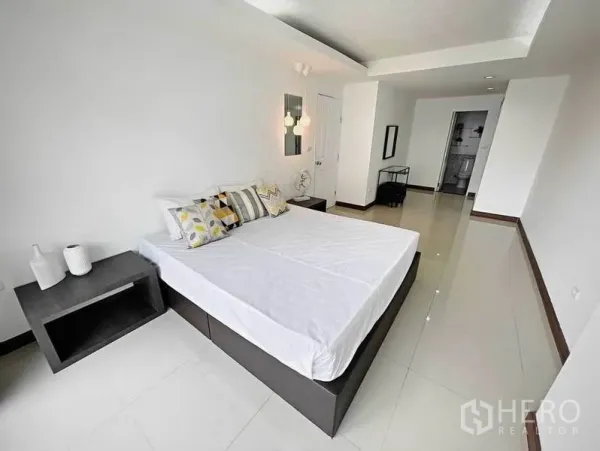 Condominium for rent in Khlong Toei, Bangkok - Wide view of the master bedroom showing minimalist decor and polished tile flooring.