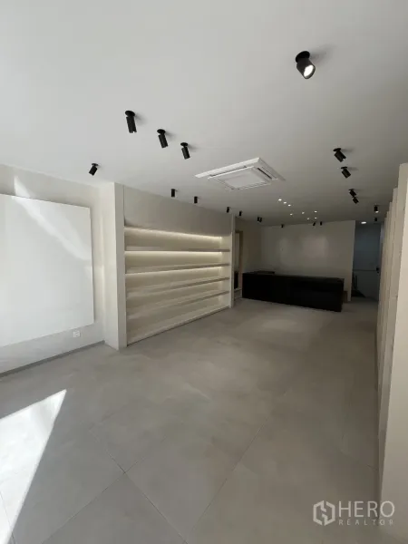 Retail Space for rent in Bangkok - Minimalist retail interior with tiled floor, ceiling spotlights and illuminated display shelves