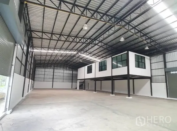 Warehouse for rent in Bang Khen, Bangkok - Spacious clear-span warehouse interior with high steel truss roof and mezzanine offices.