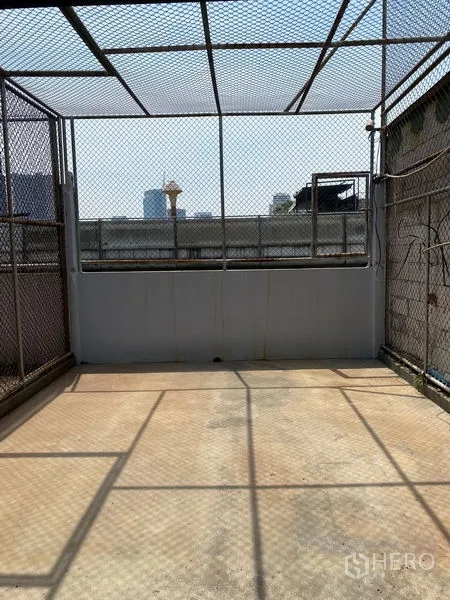 Shophouse for rent - Rooftop terrace enclosed with metal mesh, partial city views and open sky.