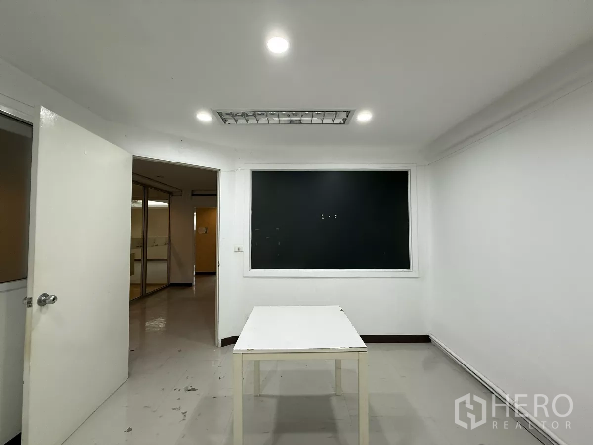 Office Space for rent in Din Daeng, Bangkok - White meeting room with a central table, bright ceiling lights and an interior window.