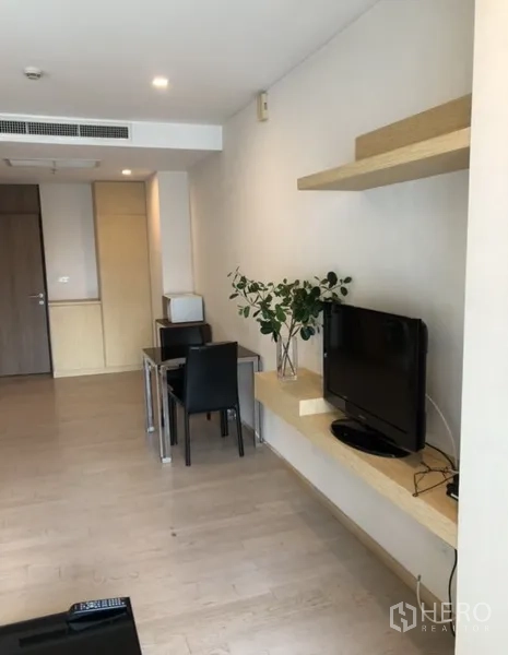 Condominium for rent in Khlong Toei, Bangkok - Floating TV shelf with flat-screen, two-seat dining set and light wood flooring.