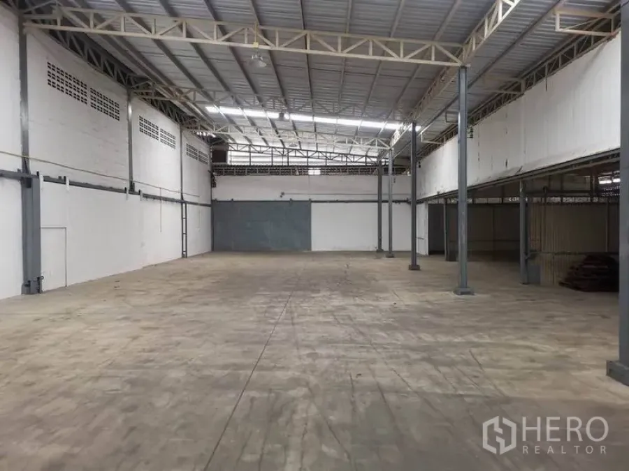 Warehouse for rent in Suan Luang, Bangkok - Spacious warehouse interior in Suan Luang with high steel truss roof, skylights and smooth concrete floor.