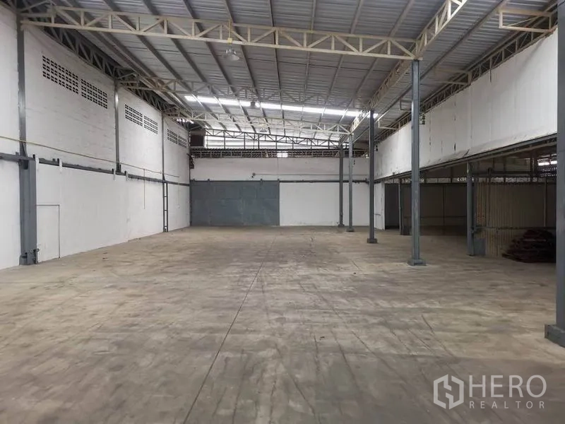 Warehouse for rent in Suan Luang, Bangkok - Spacious warehouse interior in Suan Luang with high steel truss roof, skylights and smooth concrete floor.