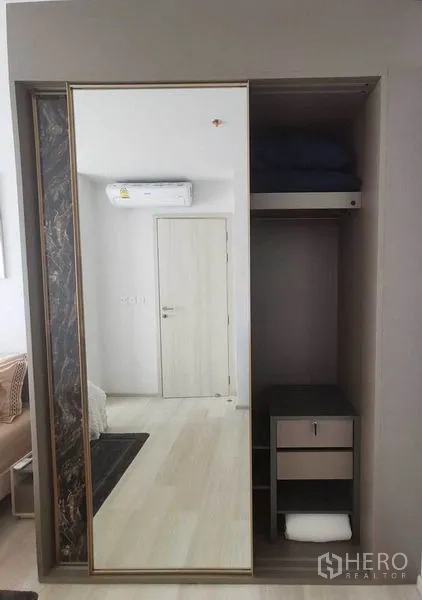 Condominium for rent in Pathum Wan, Bangkok - Built-in wardrobe with mirrored sliding door and storage shelves.