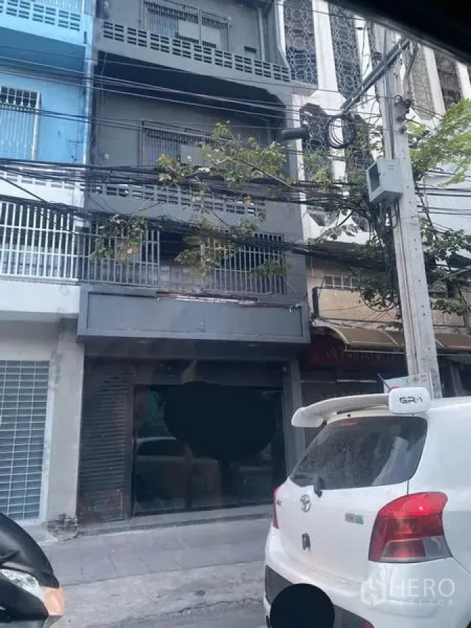 Shophouse for rent in Watthana, Bangkok - Street-facing multi-storey shophouse exterior with balcony and roller shutter
