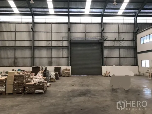 工厂 出租在Khlong Luang, Pathum Thani - 中央装卸区正对高卷帘门，顶部采光窗与开阔地面空间。