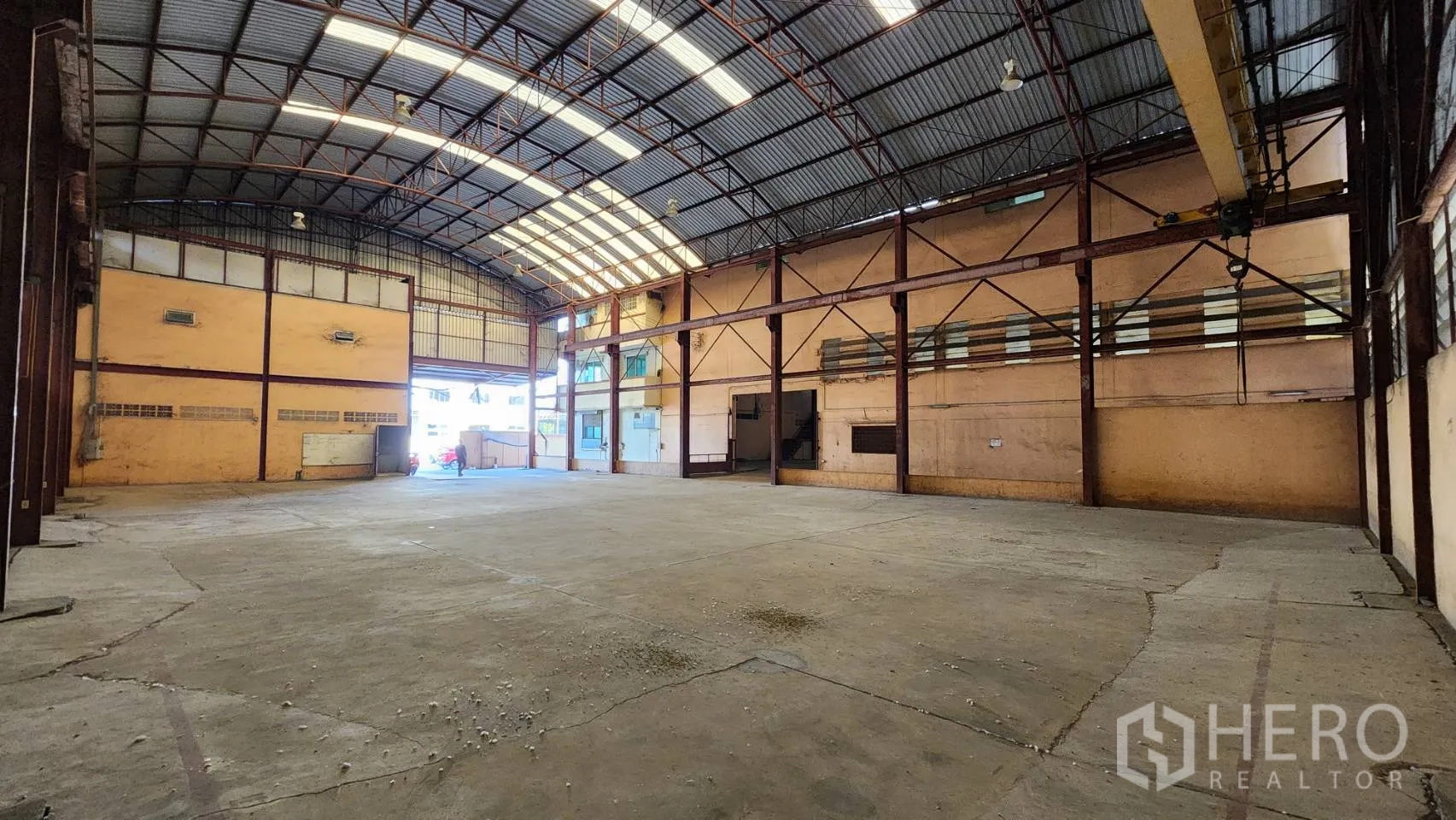 Warehouse for rent in Nonthaburi - Large open warehouse floor with tall truss roof and loading bay access.