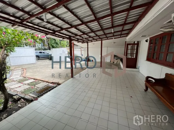 Detached House for rent in Watthana, Bangkok - Covered tiled carport and front veranda with a wooden bench.