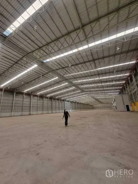 Factory for rent in Bang Pakong, Chachoengsao - Expansive factory hall with high steel truss roof, skylight panels and wide column‑free concrete floor.