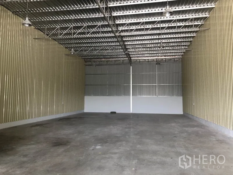 Factory for rent in Khlong Luang, Pathum Thani - Spacious warehouse interior with high steel-truss ceiling, metal cladding and polished concrete floor.