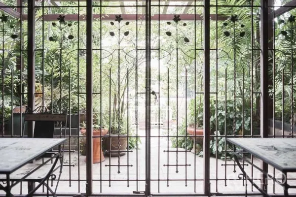 Townhouse for rent in Khlong Toei, Bangkok - Gated patio with decorative ironwork opening to a leafy garden courtyard