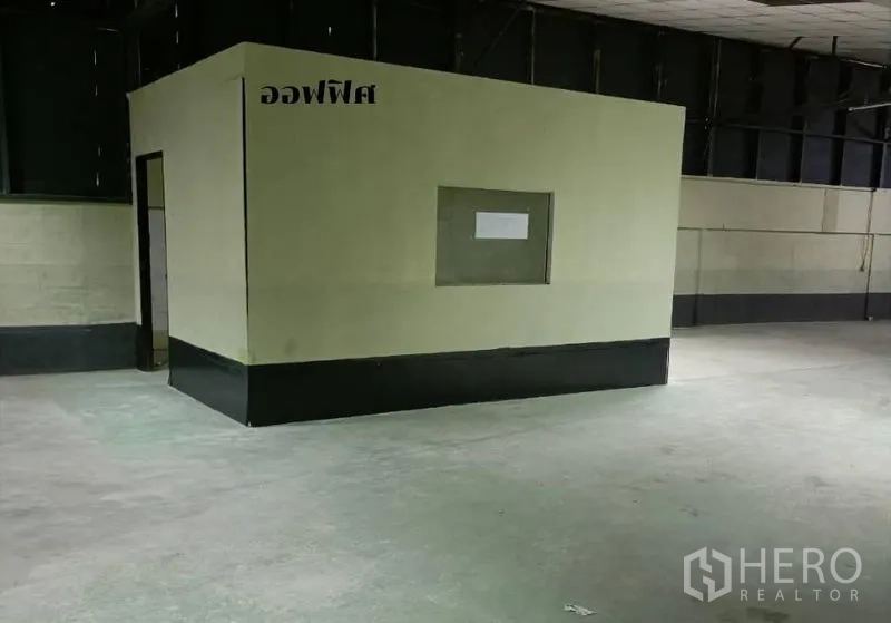 Warehouse for rent in Bang Khen, Bangkok - Freestanding office cabin with service window set on the warehouse floor.