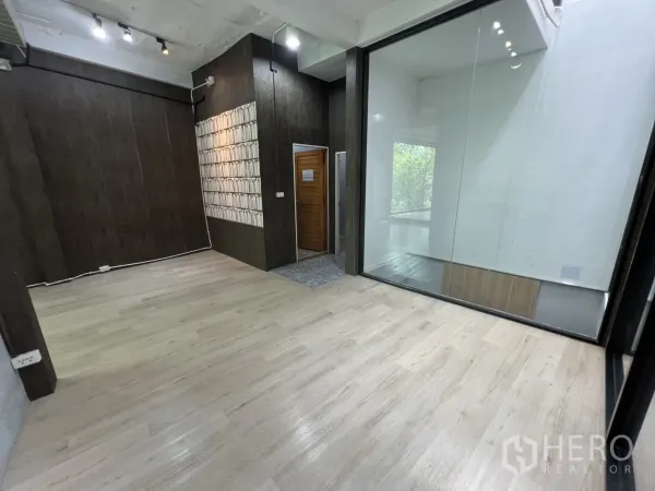 Retail Space for rent in Watthana, Bangkok - Sectioned retail zone featuring a dark wood accent wall and a large interior glass partition.