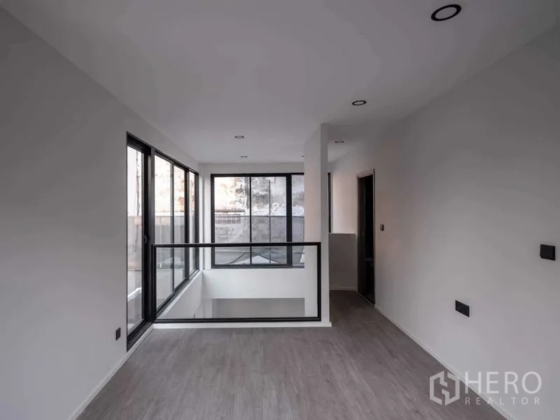 Home Office for sale in Lat Phrao, Bangkok - Mezzanine landing with glass balustrade and corner windows.