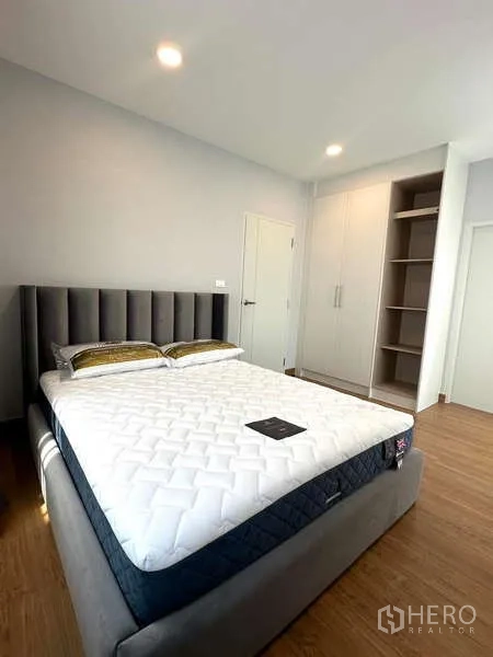 Detached House for rent in Bang Phli, Samut Prakan - Bedroom with padded headboard, fitted wardrobes and wood-look flooring.