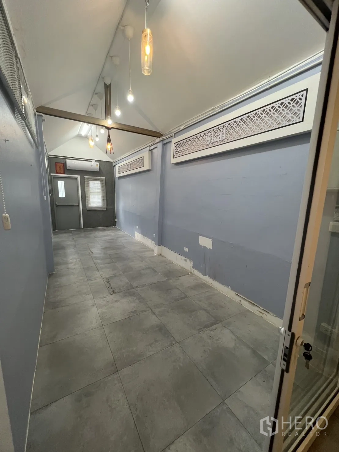 Retail Space for rent - Retail space under a pitched ceiling with decorative vents and pendant lighting, viewed from the doorway.
