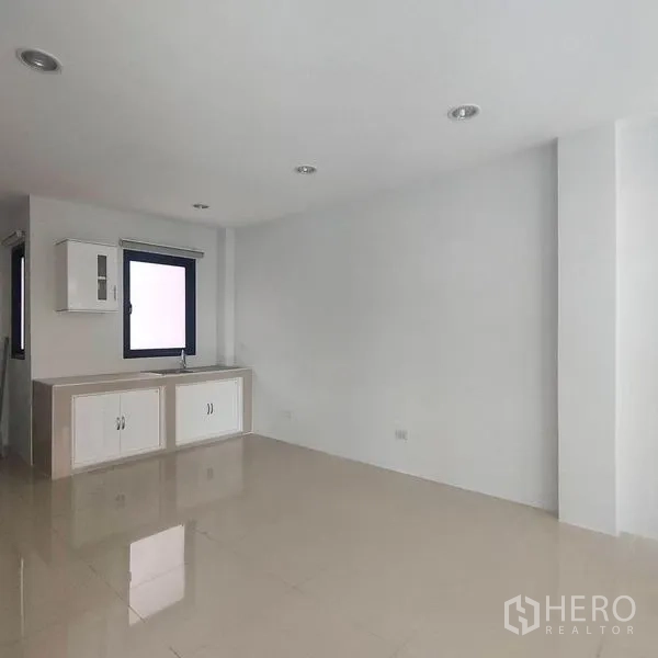 Home Office for rent in Phra Khanong, Bangkok - Bright pantry corner with white built-in cabinets, window and glossy tiled floor.