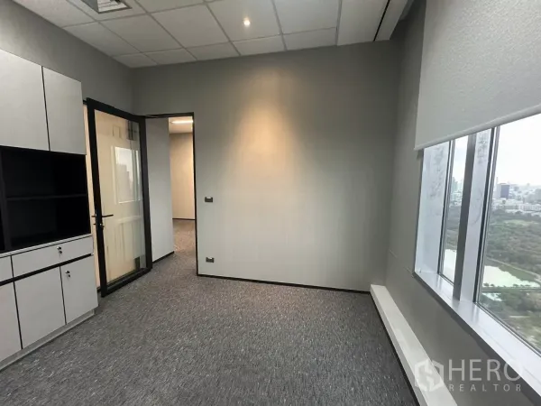 Office Space for rent in Watthana, Bangkok - Private office with cabinets, glass door and a wide city-view window.