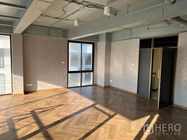 Office Space for rent or sale in Suan Luang, Bangkok - Sunlit open-plan office with herringbone wood floors, exposed ceiling, and large windows in Suan Luang, Bangkok.