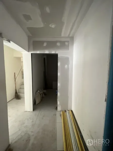Shophouse for rent in Watthana, Bangkok - Hallway under renovation with drywall finishes and a storage nook.