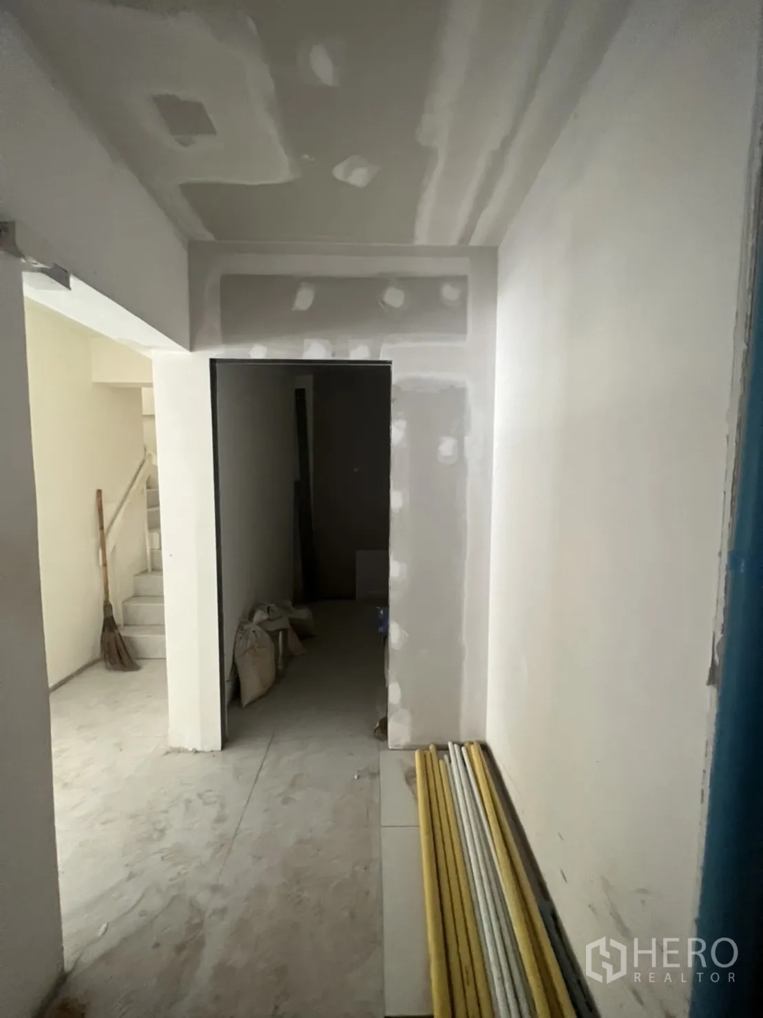 Shophouse for rent in Watthana, Bangkok - Hallway under renovation with drywall finishes and a storage nook.