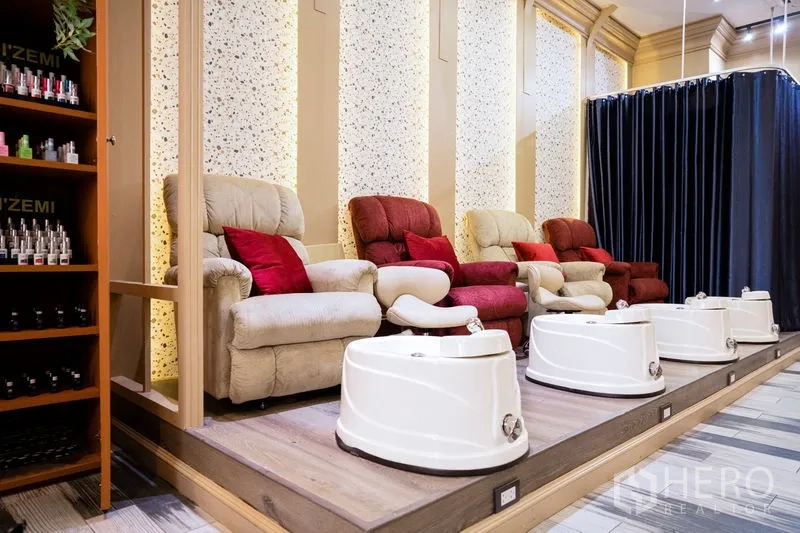 Retail Space for rent in Khlong Toei, Bangkok - Row of plush pedicure chairs with foot tubs on a raised platform and product shelving.