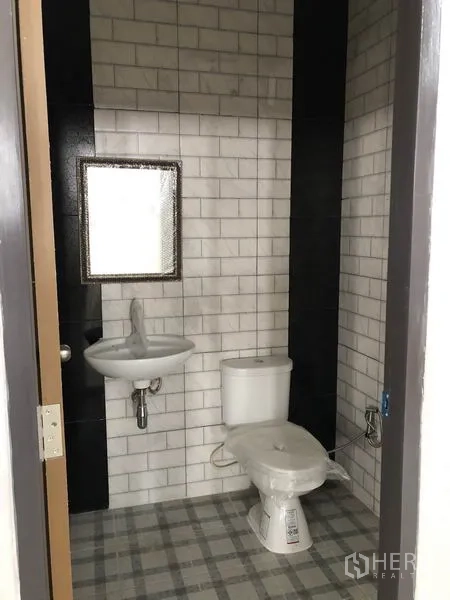 Factory for rent or sale in Bang Len, Nakhon Pathom - Clean restroom with white subway tiles, pedestal sink, mirror and toilet.
