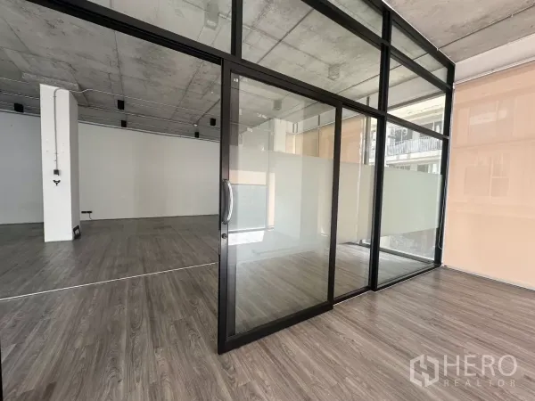 Retail Space for rent - Close-up of the black-framed glass room with sliding door and frosted panels inside the retail unit.