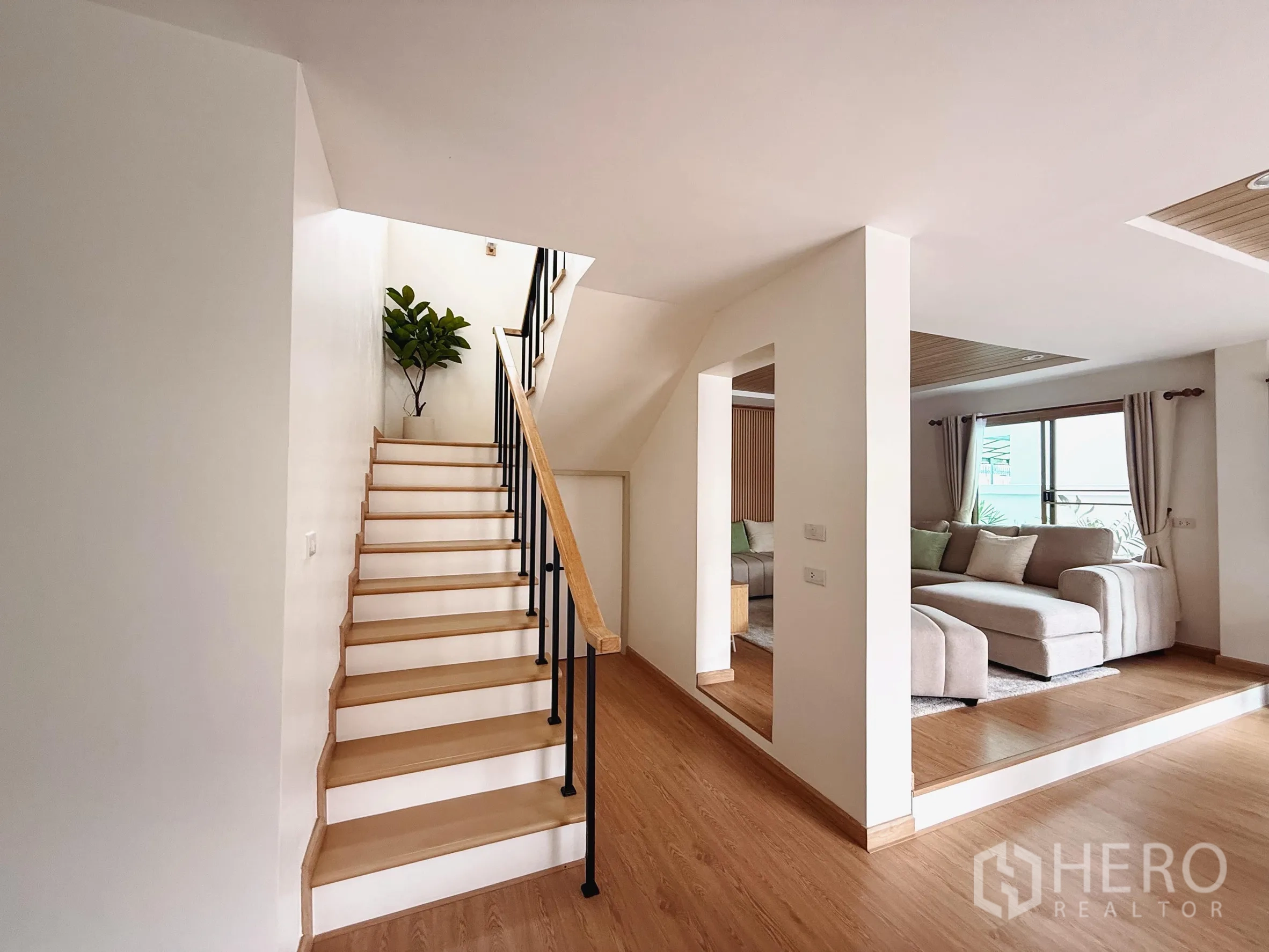 Detached House for sale in Suan Luang, Bangkok - Staircase with wood treads and black railing next to the living area.