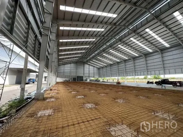 Warehouse for rent in Wang Noi, Phra Nakhon Si Ayutthaya - Spacious steel warehouse with skylit roof and reinforced floor base ready for concrete.