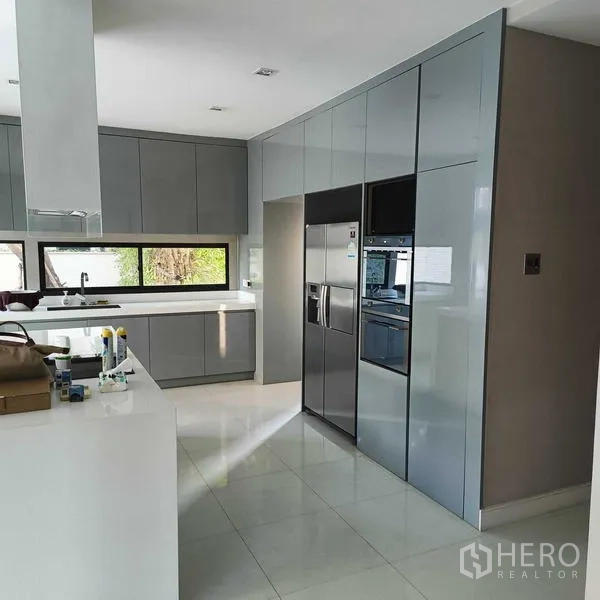 Detached House for rent or sale in Mueang Nonthaburi, Nonthaburi - Modern gray kitchen with island, built-in oven and double-door refrigerator.