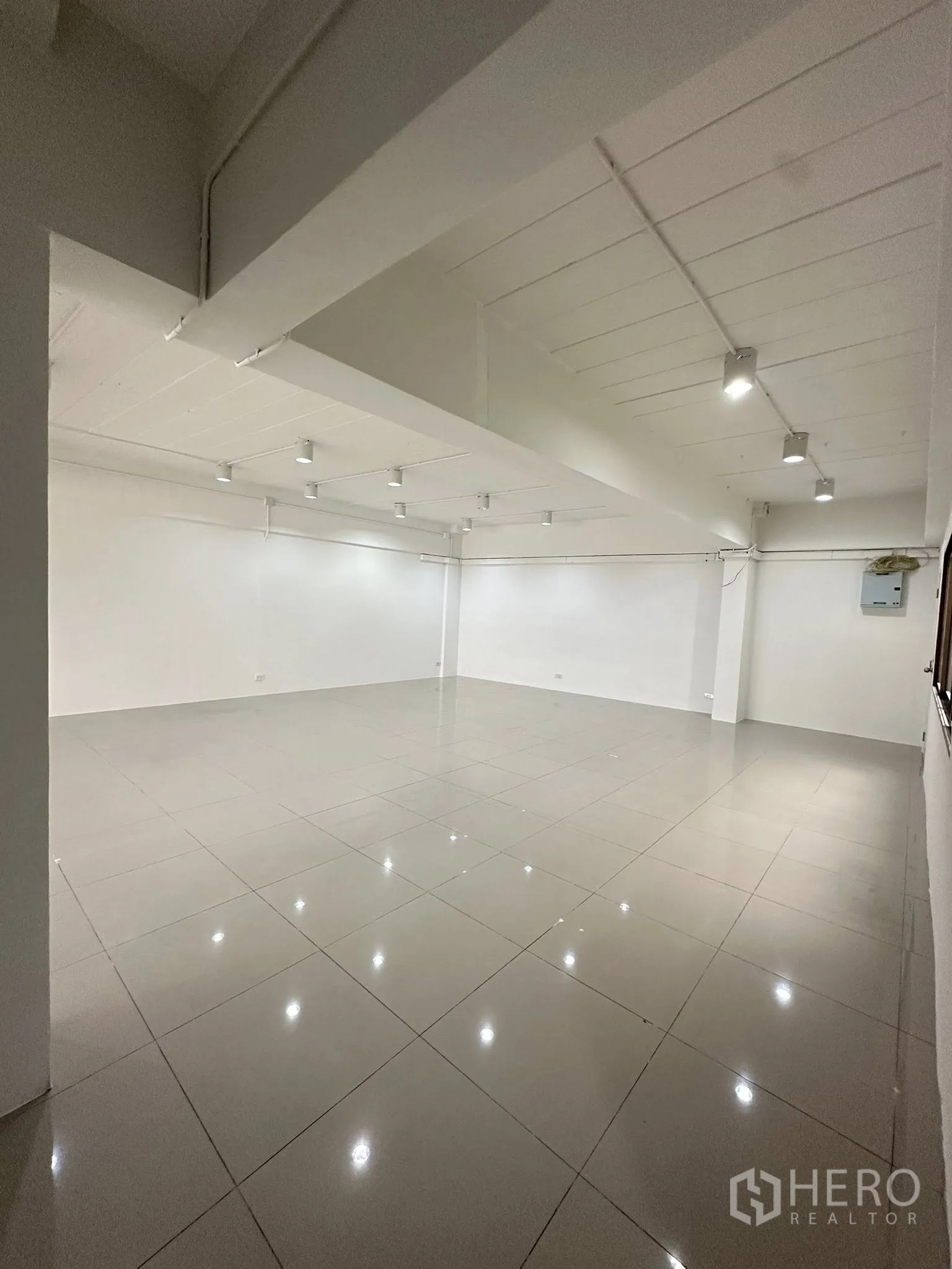 Office Space for rent in Watthana, Bangkok - Open-plan office with white ceiling spotlights and glossy tiled floor.