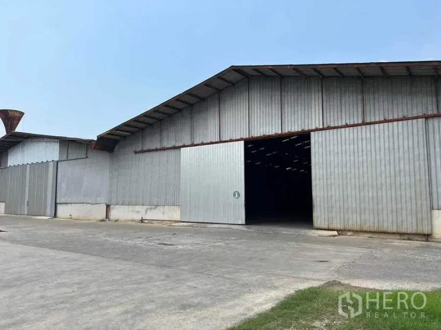 Warehouse for rent in Bang Pa-in, Phra Nakhon Si Ayutthaya - Corrugated metal warehouse exterior with a large sliding entrance and driveway.
