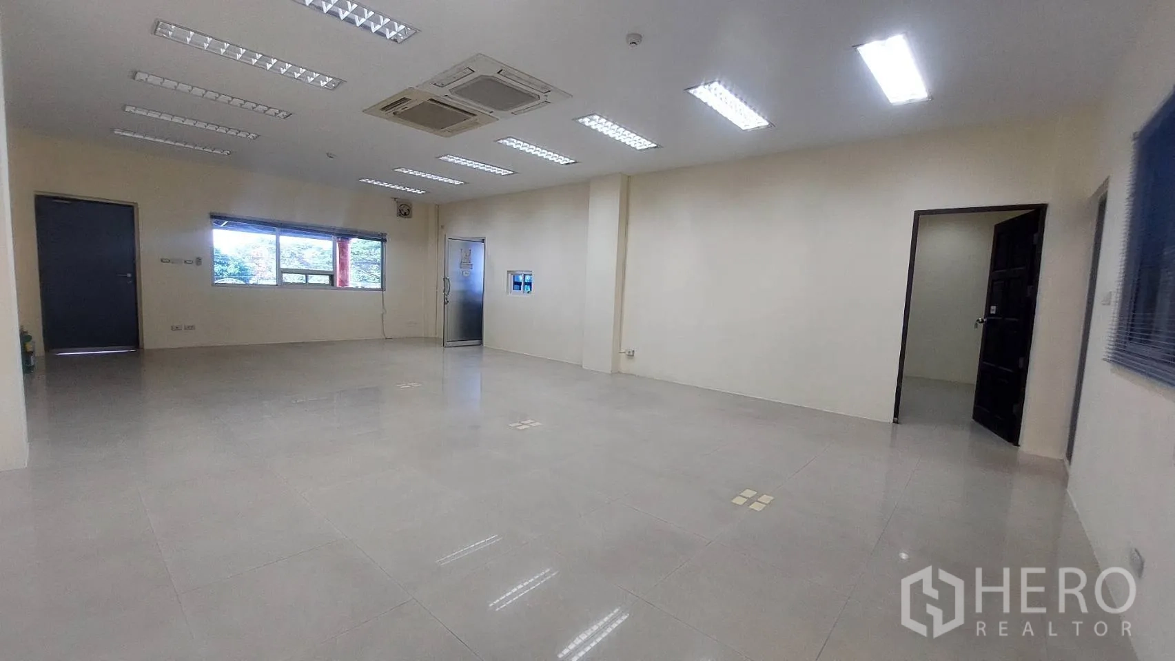 Warehouse for rent in Mueang Pathum Thani, Pathum Thani - Additional office space with windows, ceiling AC, and bright tile flooring.