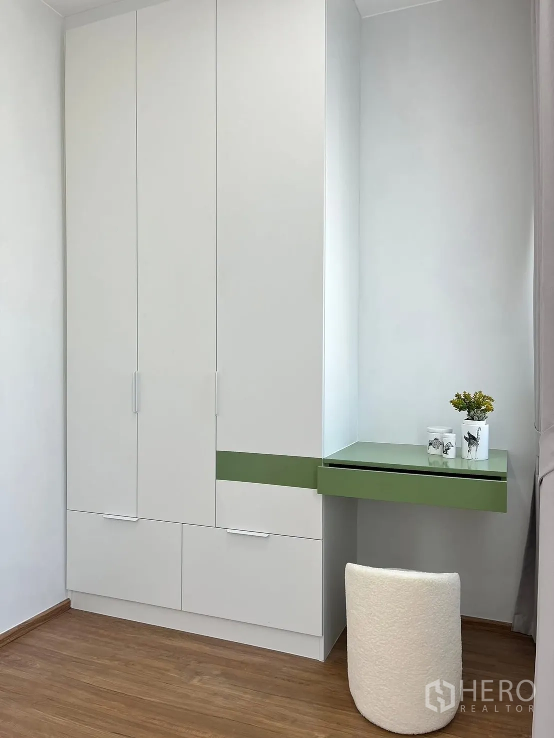 Townhouse for rent in Bang Phli, Samut Prakan - Built-in white wardrobe with green accent and a compact dressing table with stool.