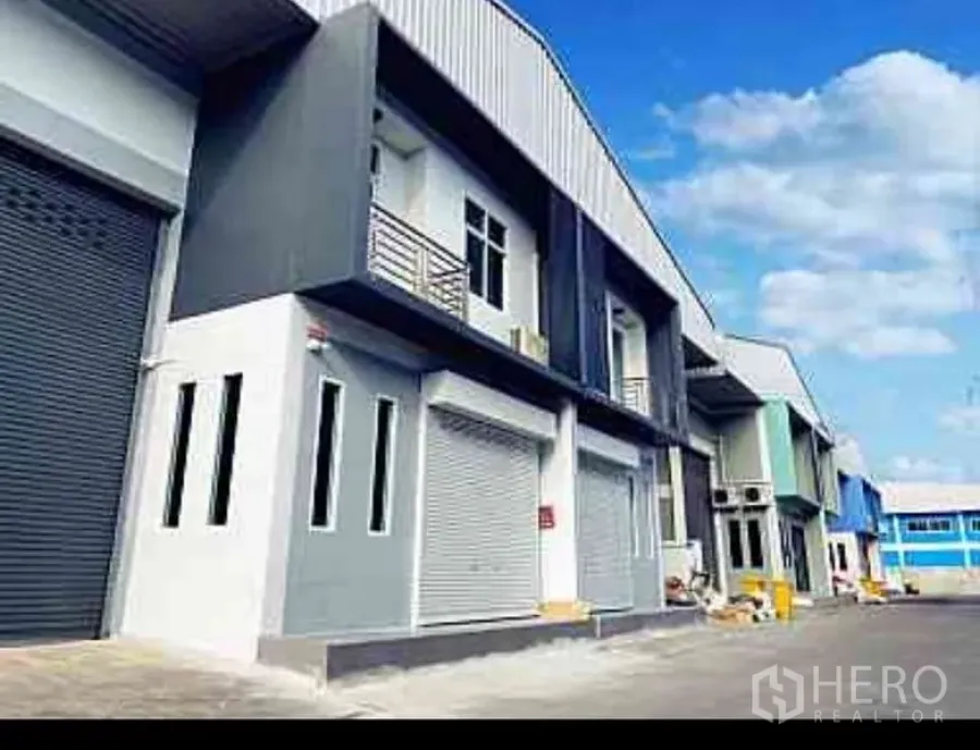 Factory for rent in Mueang Samut Sakhon, Samut Sakhon - Contemporary factory facades with balconies, multiple windows, and truck-friendly access road.