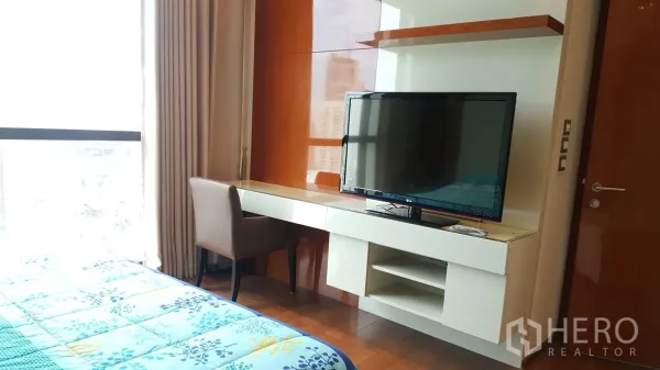 Condominium for rent or sale in Khlong Toei, Bangkok - Bedroom study corner with built-in desk, shelving and a flat-screen TV opposite the bed.