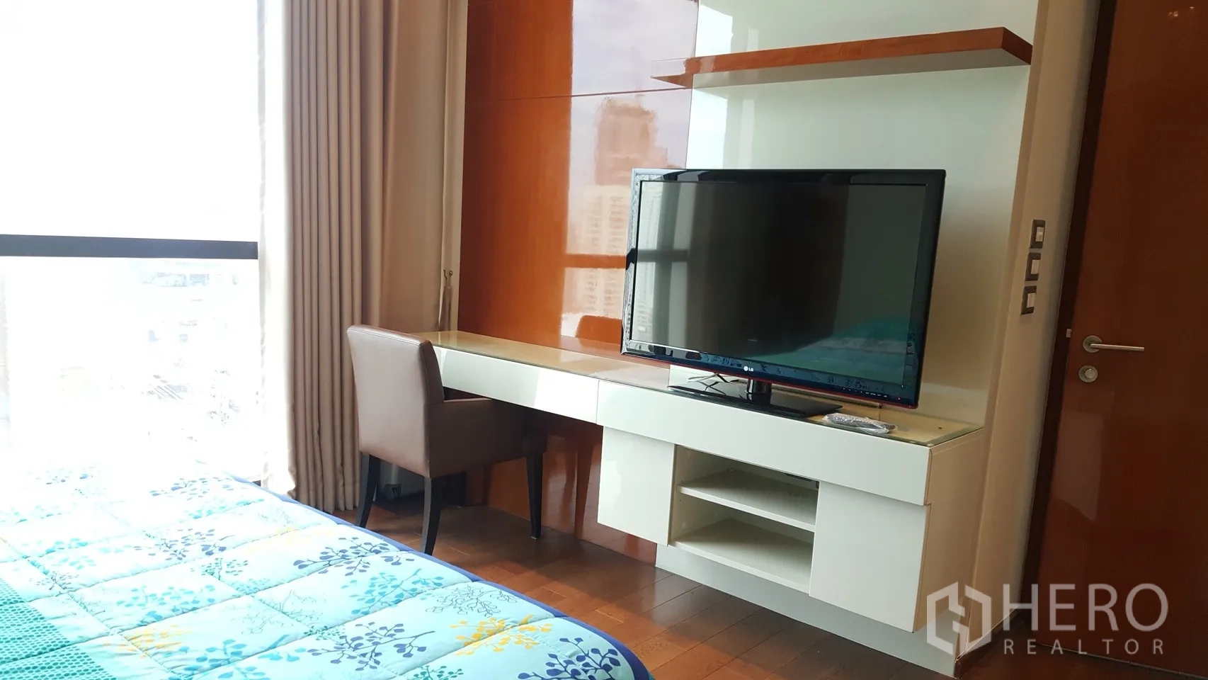 Condominium for rent or sale in Khlong Toei, Bangkok - Bedroom study corner with built-in desk, shelving and a flat-screen TV opposite the bed.