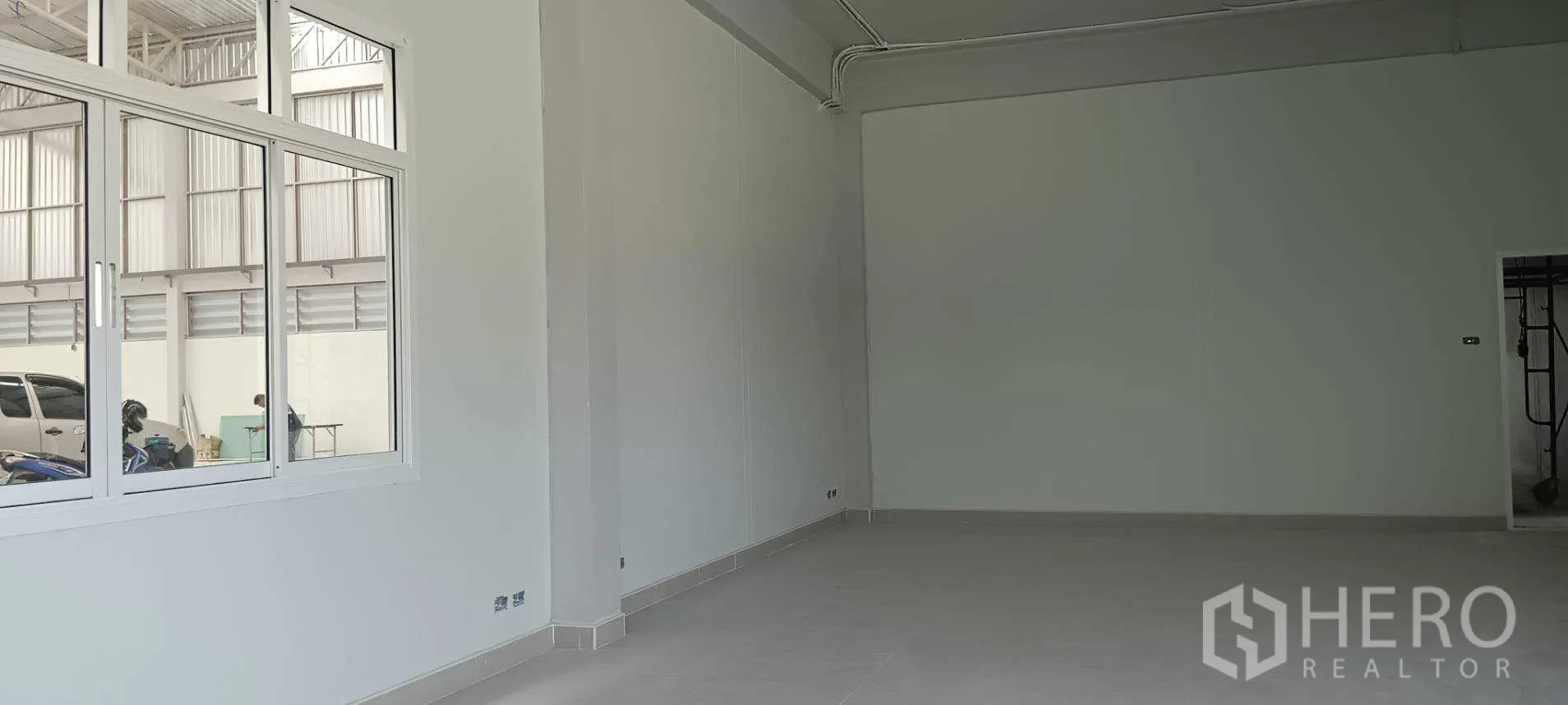 Warehouse for rent or sale in Lam Luk Ka, Pathum Thani - Bright office room with tiled floor and a large window overlooking the warehouse.