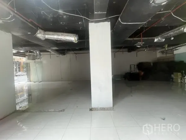 Retail Space for rent in Watthana, Bangkok - Large columned retail floor plate with tiled flooring and black exposed services.