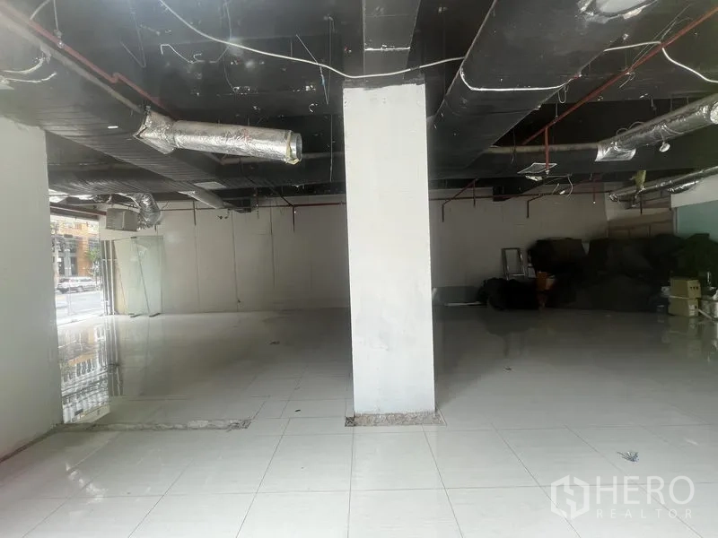 Retail Space for rent in Watthana, Bangkok - Large columned retail floor plate with tiled flooring and black exposed services.
