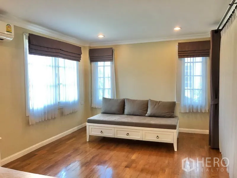 Detached House for rent in Mueang Samut Prakan, Samut Prakan - Airy multipurpose room with wood flooring, corner windows and daybed with storage drawers.